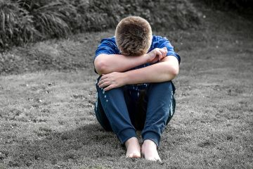 A boy with head in his hands